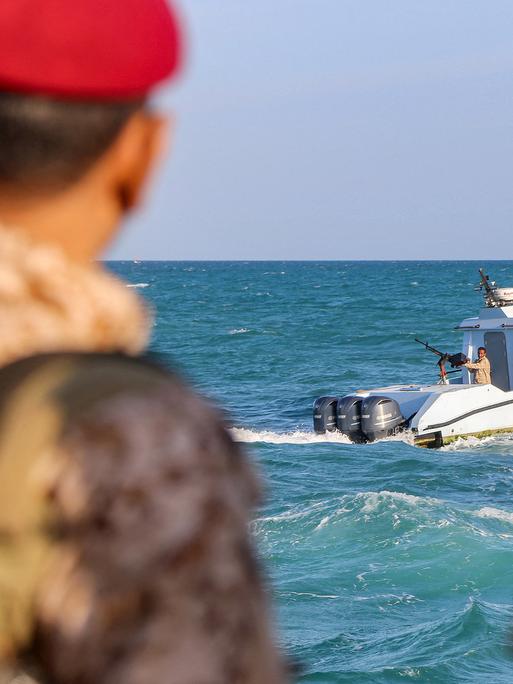 Uniformierte jemenitische Mitglieder der Küstenwachen schauen von einem Boot aus aufs Meer hinaus.