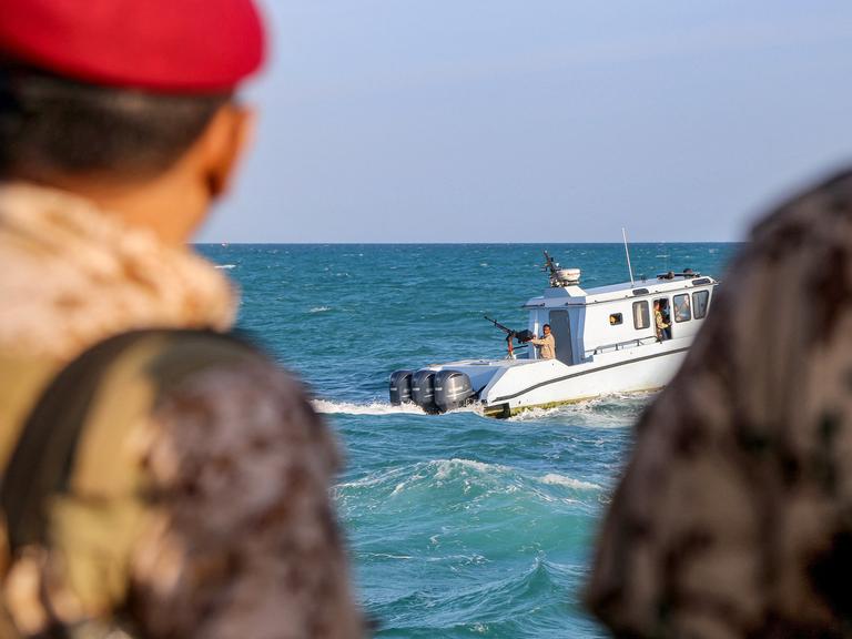 Uniformierte jemenitische Mitglieder der Küstenwachen schauen von einem Boot aus aufs Meer hinaus.