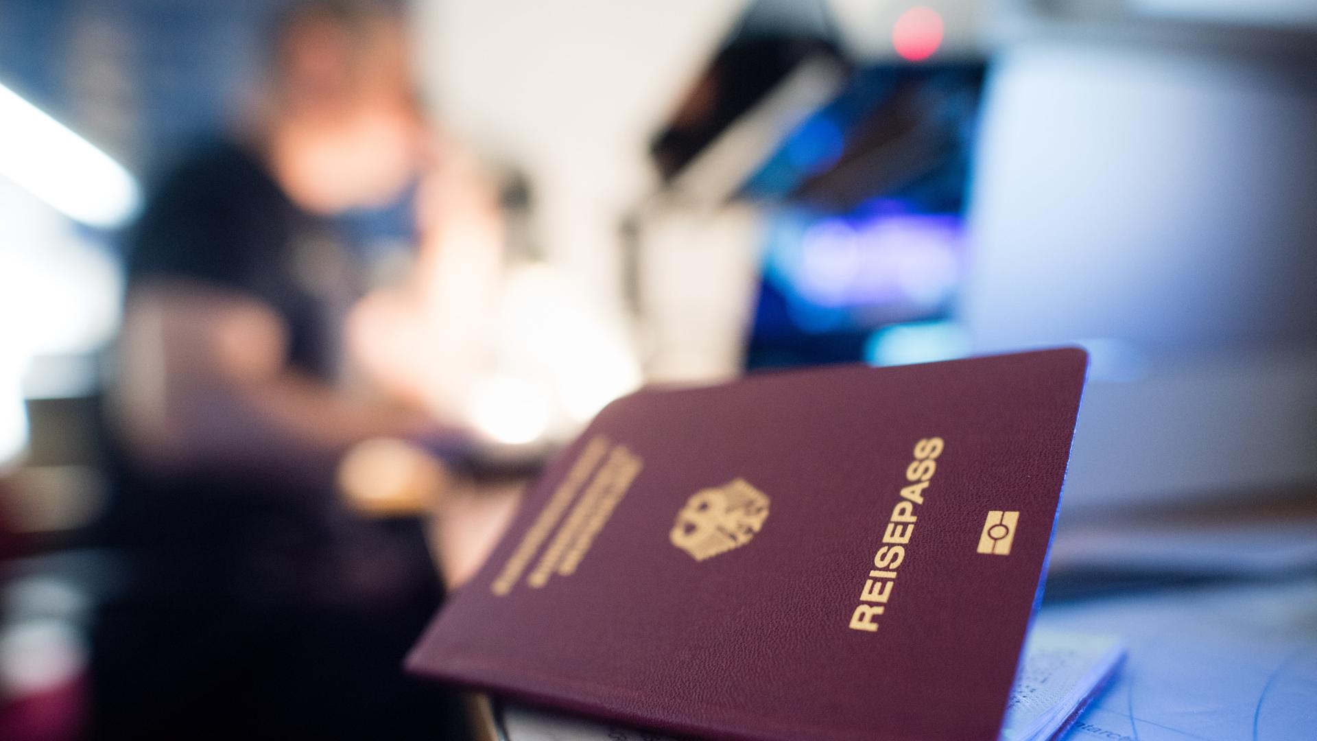 München: Ein deutscher Reisepass liegt in einem Labor der Kriminaltechnik der Bundespolizei am Flughafen, während im Hintergrund ein Urkundenprüfer der Bundespolizei an einem Mikroskop arbeitet. München: Ein deutscher Reisepass liegt in einem Labor der Kriminaltechnik der Bundespolizei am Flughafen, während im Hintergrund ein Urkundenprüfer der Bundespolizei an einem Mikroskop arbeitet.