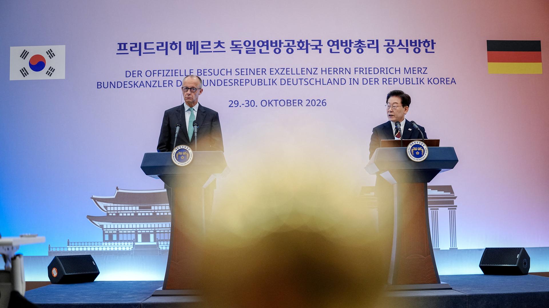 Seoul: Bundeskanzler Friedrich Merz (CDU,l) und der südkoreanische Präsident Lee Jae Myung, Präsident der Republik Korea, stehen an zwei Rednerpulten vor einer blauen Wand mit koreanischer Schrift. Seoul: Bundeskanzler Friedrich Merz (CDU,l) und der südkoreanische Präsident Lee Jae Myung, Präsident der Republik Korea, stehen an zwei Rednerpulten vor einer blauen Wand mit koreanischer Schrift.