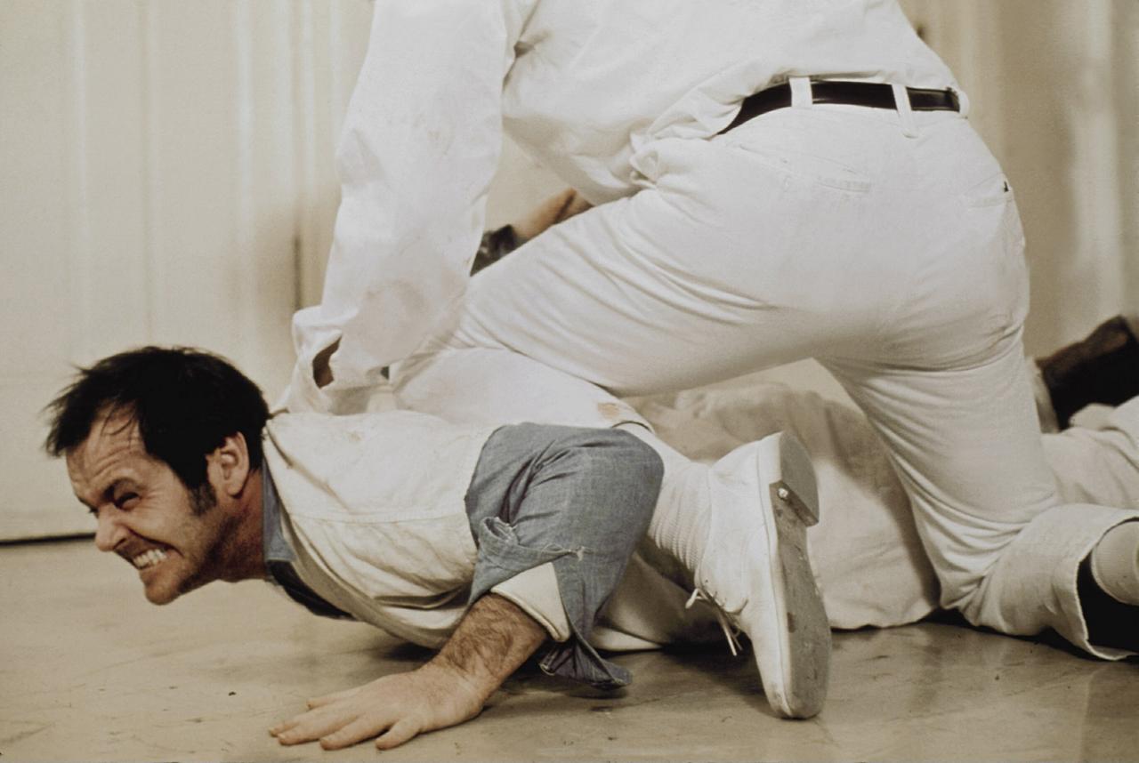 Szene aus "Einer flog übers Kuckucksnest" ("One Flew Over The Cuckoo's Nest", USA 1975, Regie: Milos Forman): Ein Mann wird von medizinischen Personal auf den Boden gedrückt. Er wehrt sich. Szene aus "Einer flog übers Kuckucksnest" ("One Flew Over The Cuckoo's Nest", USA 1975, Regie: Milos Forman): Ein Mann wird von medizinischen Personal auf den Boden gedrückt. Er wehrt sich.