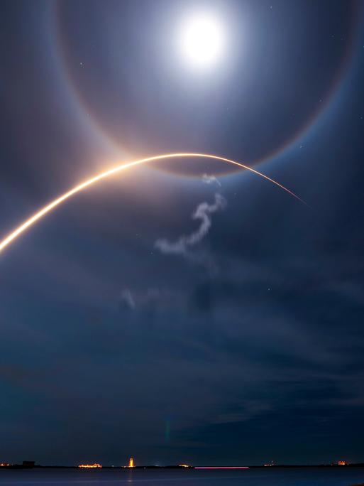 Lichtbogen einer abhebenden SpaceX-Rakete, die vom Kennedy Space Center Starlink-Satelliten in die Umlaufbahn bringt Lichtbogen einer abhebenden SpaceX-Rakete, die vom Kennedy Space Center Starlink-Satelliten in die Umlaufbahn bringt