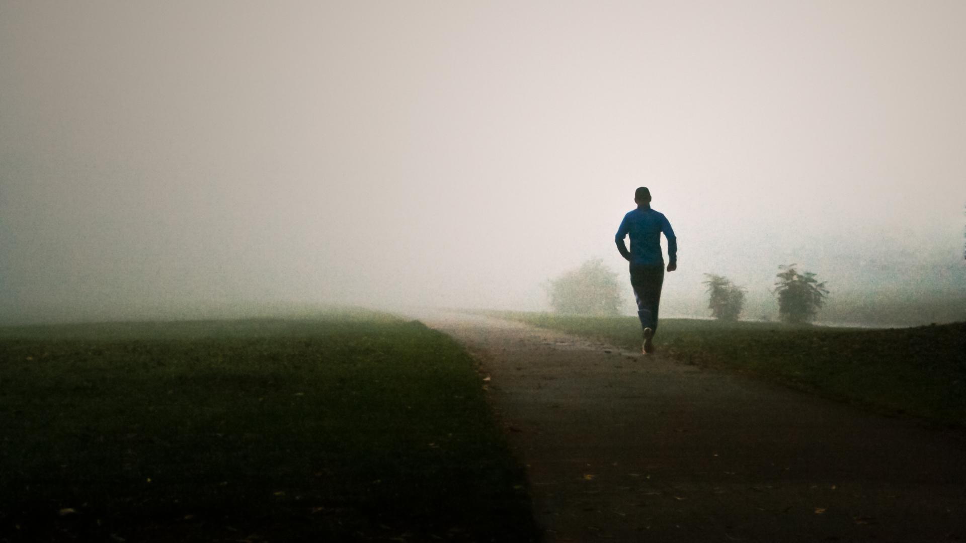 Ein Mann joggt im Nebel.