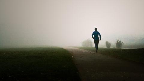 Ein Mann joggt im Nebel.