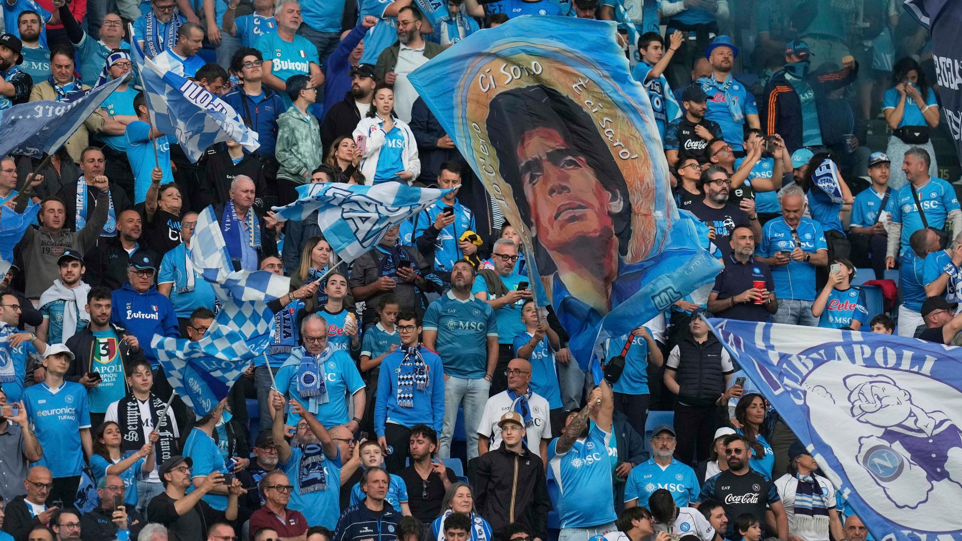 Fans von Napoli im Stadion. Sie hissen ein Plakat von Diego Maradonna. Fans von Napoli im Stadion. Sie hissen ein Plakat von Diego Maradonna.