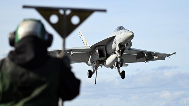 Ein Kampfjet landet auf einemUS- Flugzeugträger. Ein Kampfjet landet auf einemUS- Flugzeugträger.