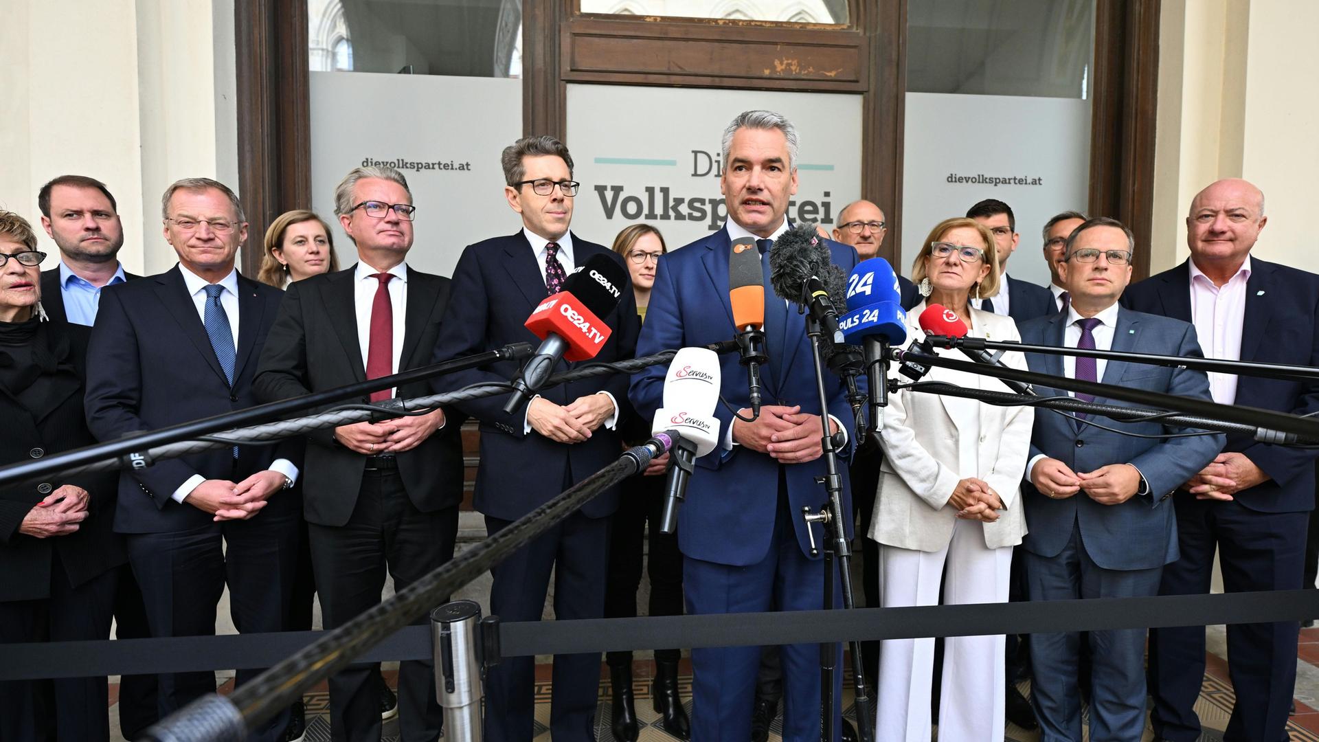 Österreich, Wien: ÖVP-Chef Karl Nehammer (M) spricht während eines Statements anlässlich des ÖVP Bundesparteivorstandes. Um ihn herum stehen mehrere Personen. 