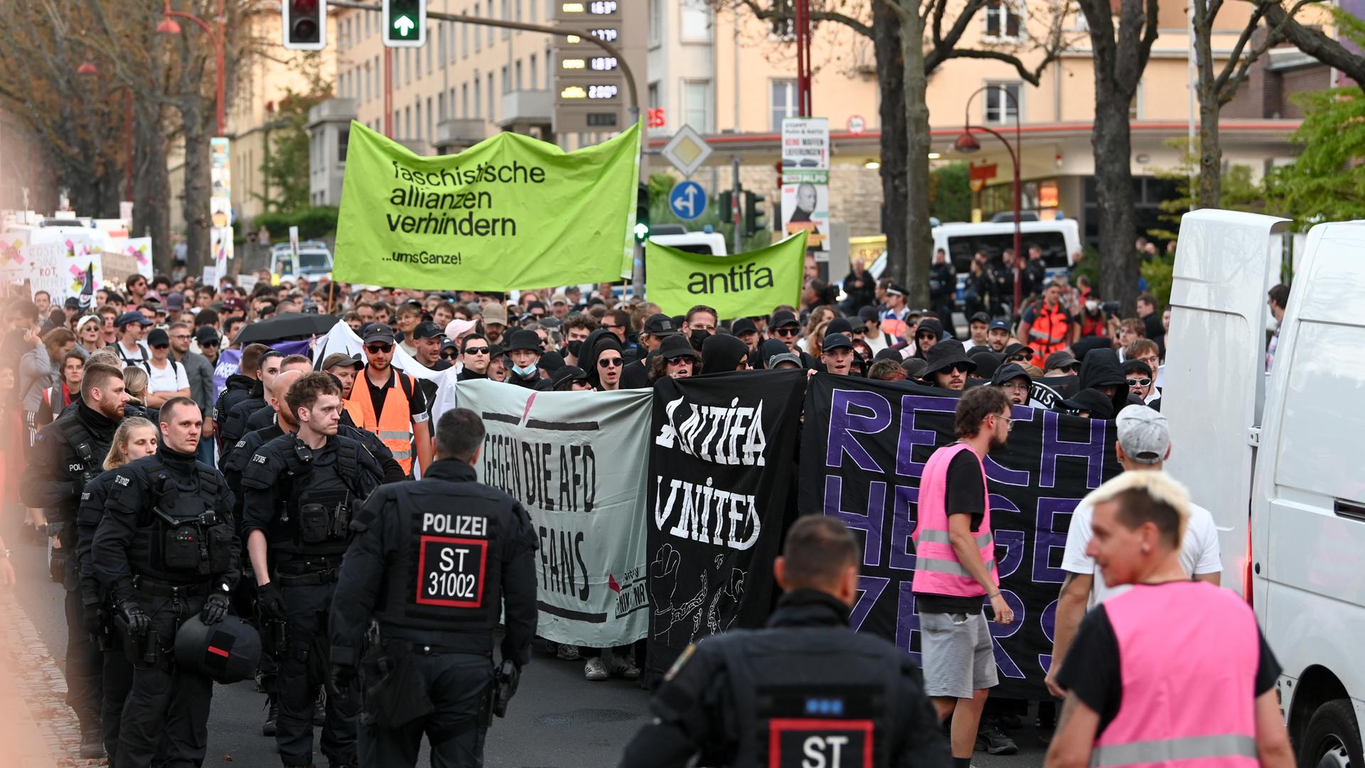 Ein Protestzug mit mehreren antifaschistischen Plakaten in Erfurt, begleitet von Polizisten.