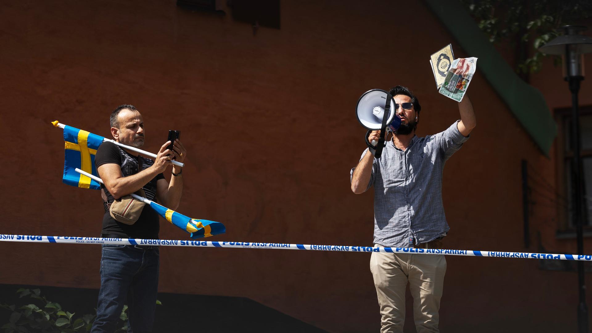  Zwei Männer protestieren vor einer Stockholmer Moschee am 28. Juni mit einem Koran in der Hand.