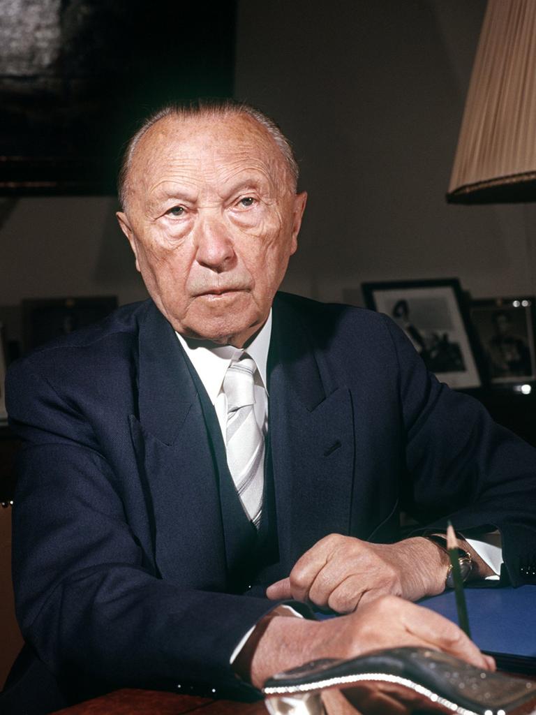 Konrad Adenauer sitzt an einem Schreibtisch.