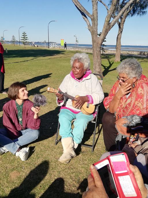 Die Autorin und zwei Damen spielen Ukulelenlieder beim Picknick der Unterdeutsch Community in Brisbane, im Juli 2018.