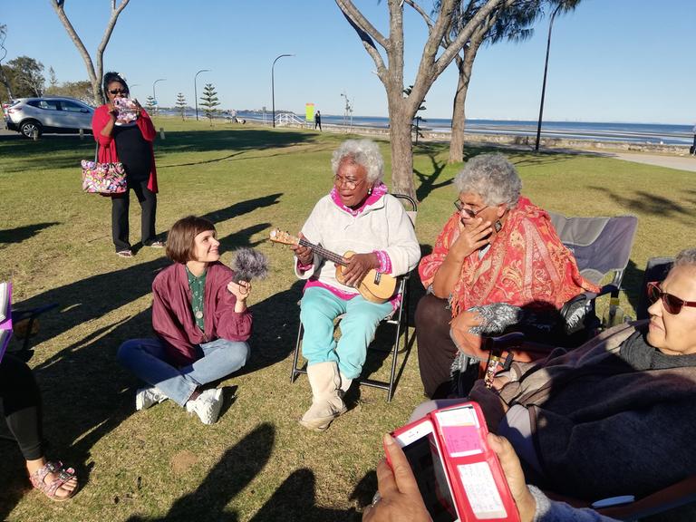 Die Autorin und zwei Damen spielen Ukulelenlieder beim Picknick der Unterdeutsch Community in Brisbane, im Juli 2018.