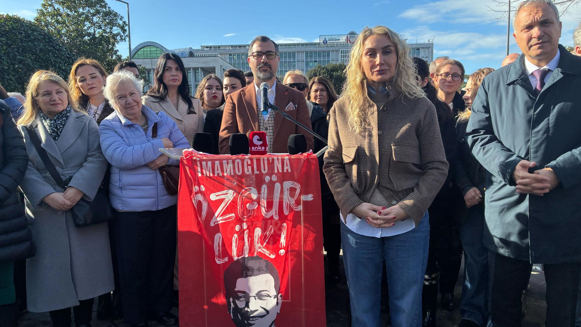 Dilek Imamoglu, Frau des inhaftierten und abgesetzten Bürgermeisters von Istanbul, nimmt an einer Kundgebung teil, auf der Freiheit für ihren Mann gefordert wird. Neben ihr stehen Männer und Frauen. Im Hintergrund ist ein Gebäude. Der Himmel ist blau. Dilek Imamoglu, Frau des inhaftierten und abgesetzten Bürgermeisters von Istanbul, nimmt an einer Kundgebung teil, auf der Freiheit für ihren Mann gefordert wird. Neben ihr stehen Männer und Frauen. Im Hintergrund ist ein Gebäude. Der Himmel ist blau.