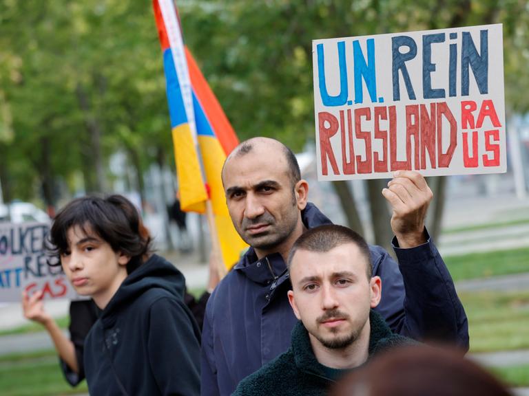 Demonstranten halten ein Schild mit der Aufschrift "U.N. rein - Russland raus".