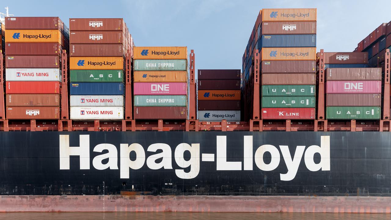 Der Schriftzug "Hapag-Lloyd" steht an der Bordwand eines Containerschiffs der gleichnamigen Reederei.