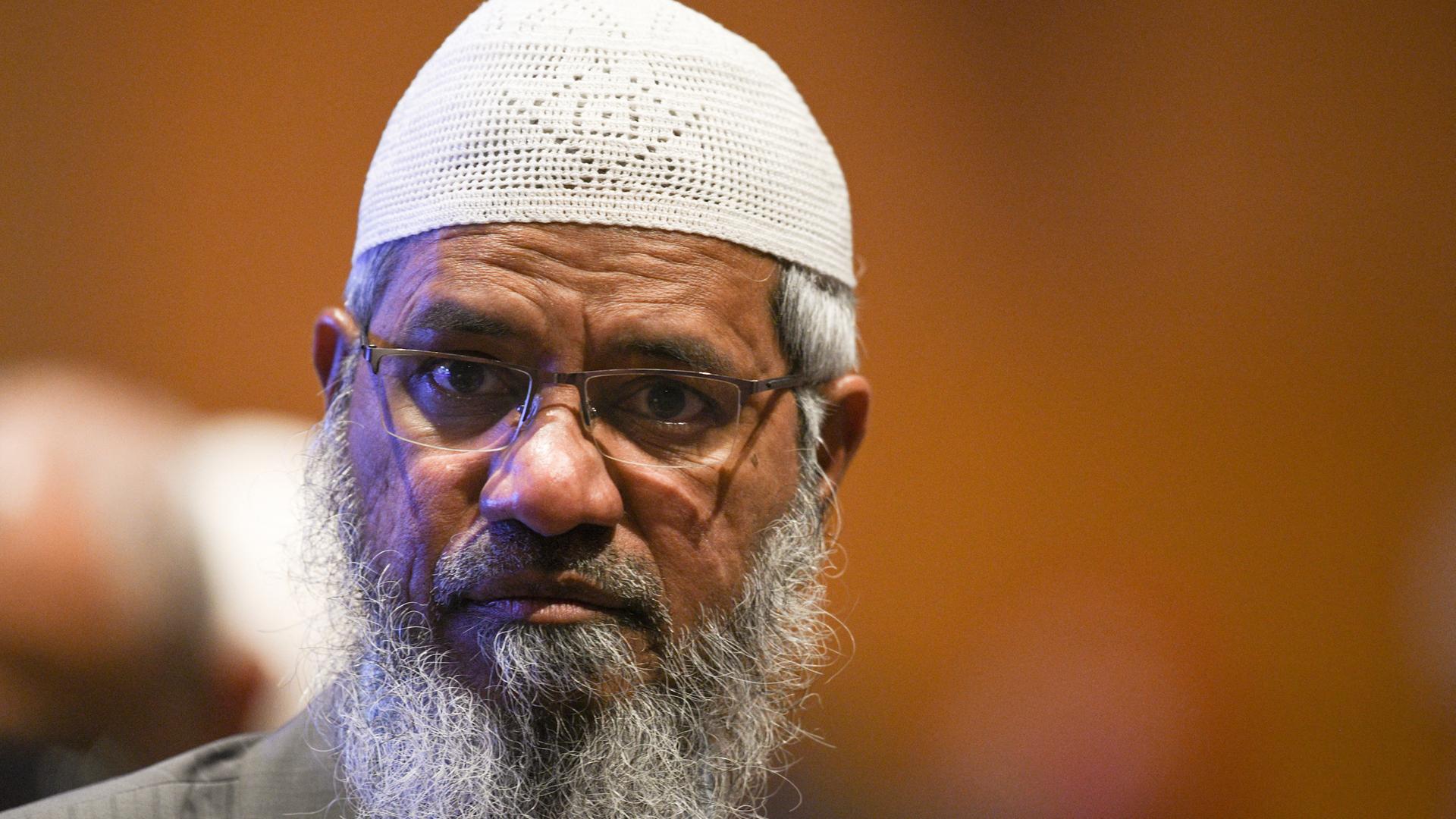 Zu sehen ist der aus Indien stammende umstrittene muslimische Fernsehprediger Zakir Naik. Er trägt Bart und eine Brille und steht vor einem farbigen Hintergrund. Aufgenommen wurde das Bild am 19. Dezember 2019.
(Photo by Mohd RASFAN / AFP)