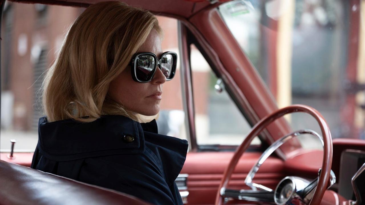 Elizabeth Banks mit Sonnenbrille sitzt am Steuer eines alten amerikanischen Straßenkreuzers. Elizabeth Banks mit Sonnenbrille sitzt am Steuer eines alten amerikanischen Straßenkreuzers.