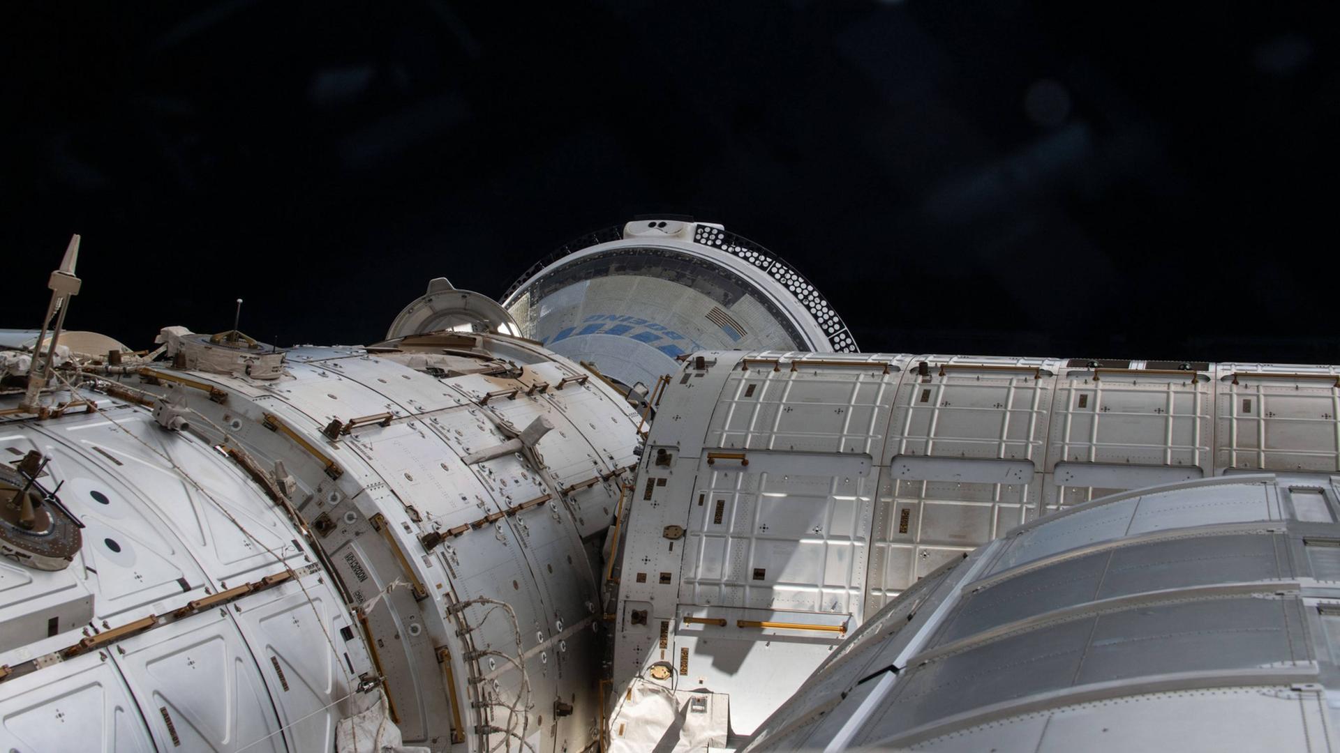 Ein Foto zeigt einen Teil der Raumstation ISS, an dem der Boeing-Starliner angedockt ist.