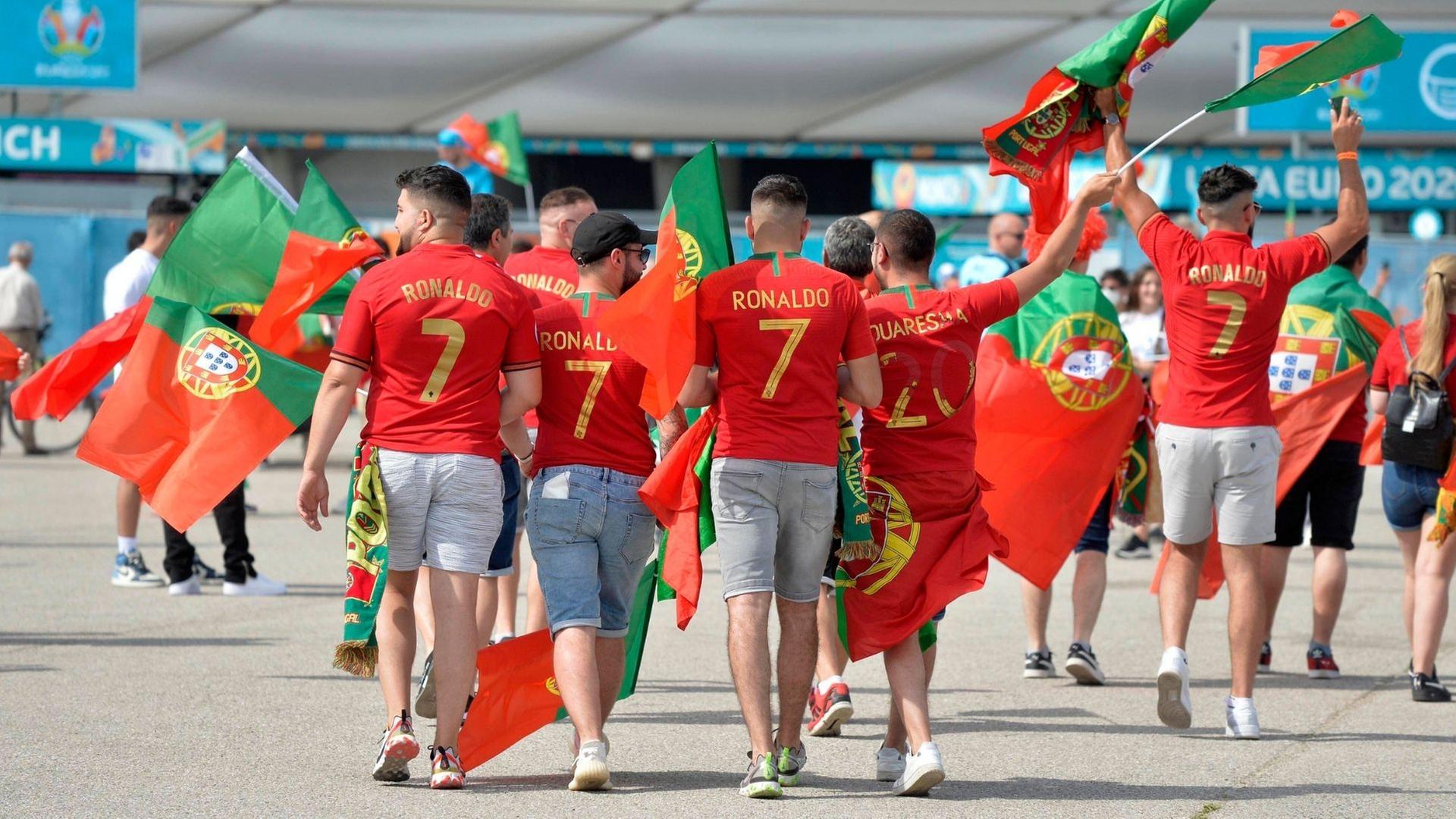 Portugiesische Fans kommen Fahnenschwenkend zum Stadion. 