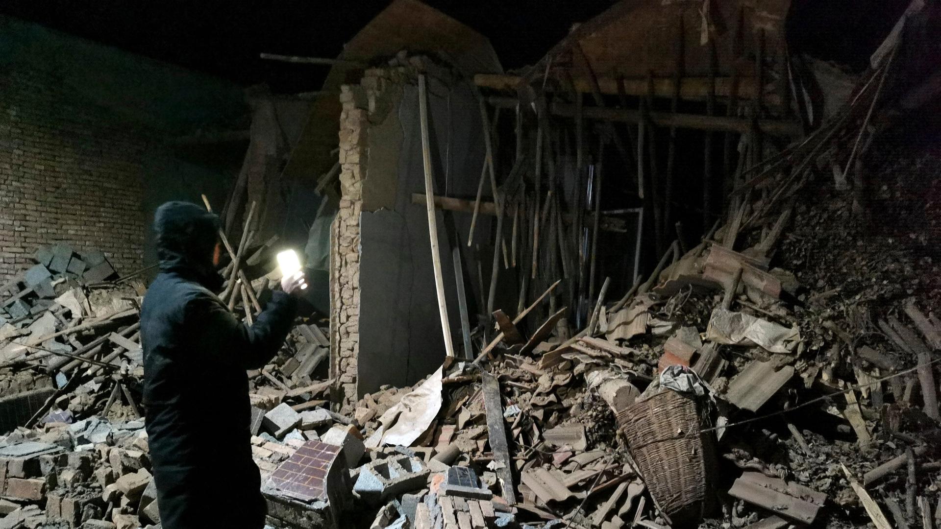 Ein Regierungsmitarbeiter betrachtet die Trümmer eines durch das Erdbeben zerstörten Hauses in der nordwestchinesischen Provinz Gansu.