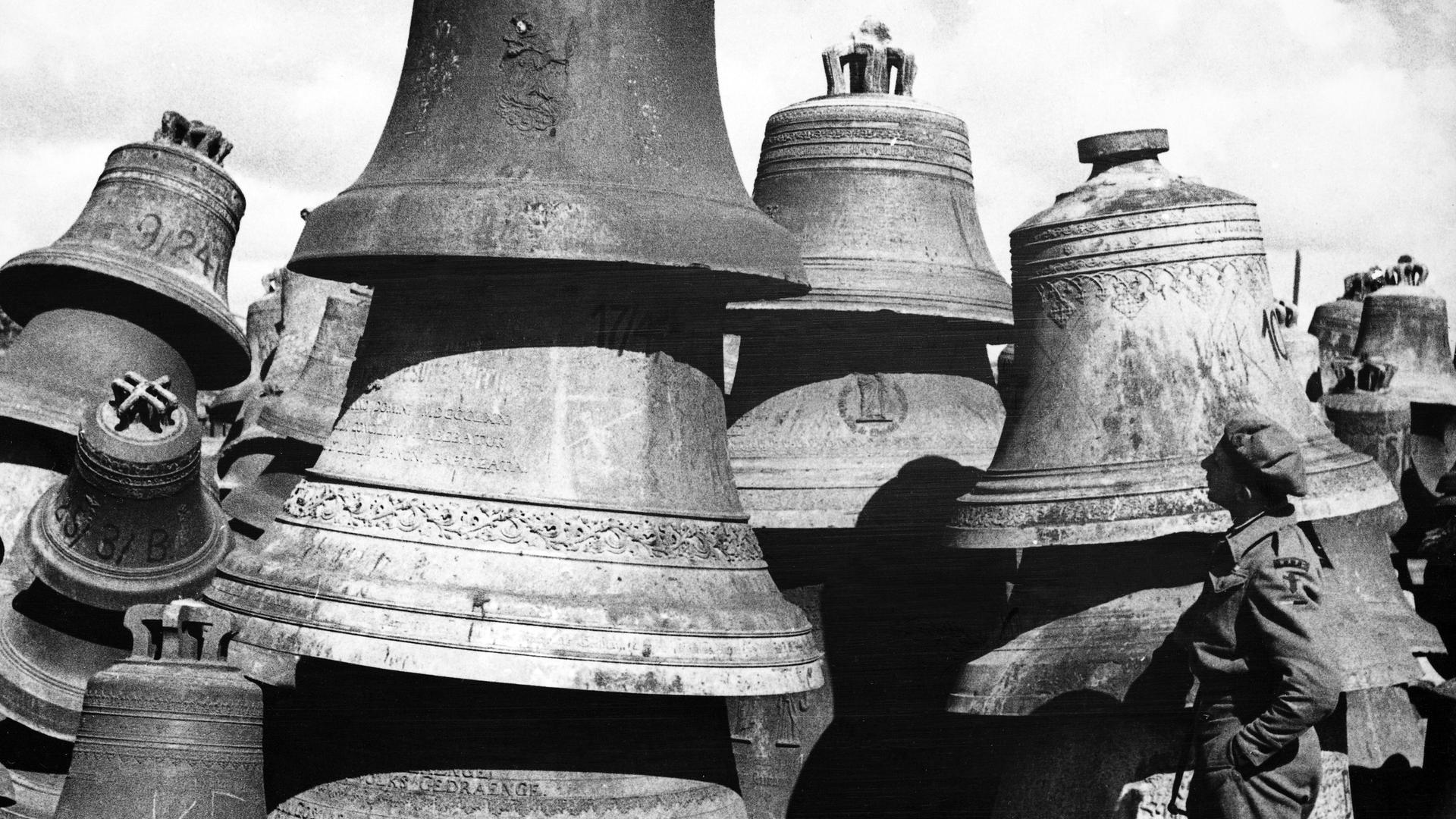 Ein britischer Soldat betrachtet Glocken ohne weitere Angaben um 1947/1948 