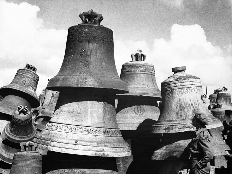 Ein britischer Soldat betrachtet Glocken ohne weitere Angaben um 1947/1948 