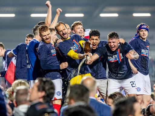 Die Spieler von Holstein Kiel feiern gemeinsam mit den Fans den Aufstieg