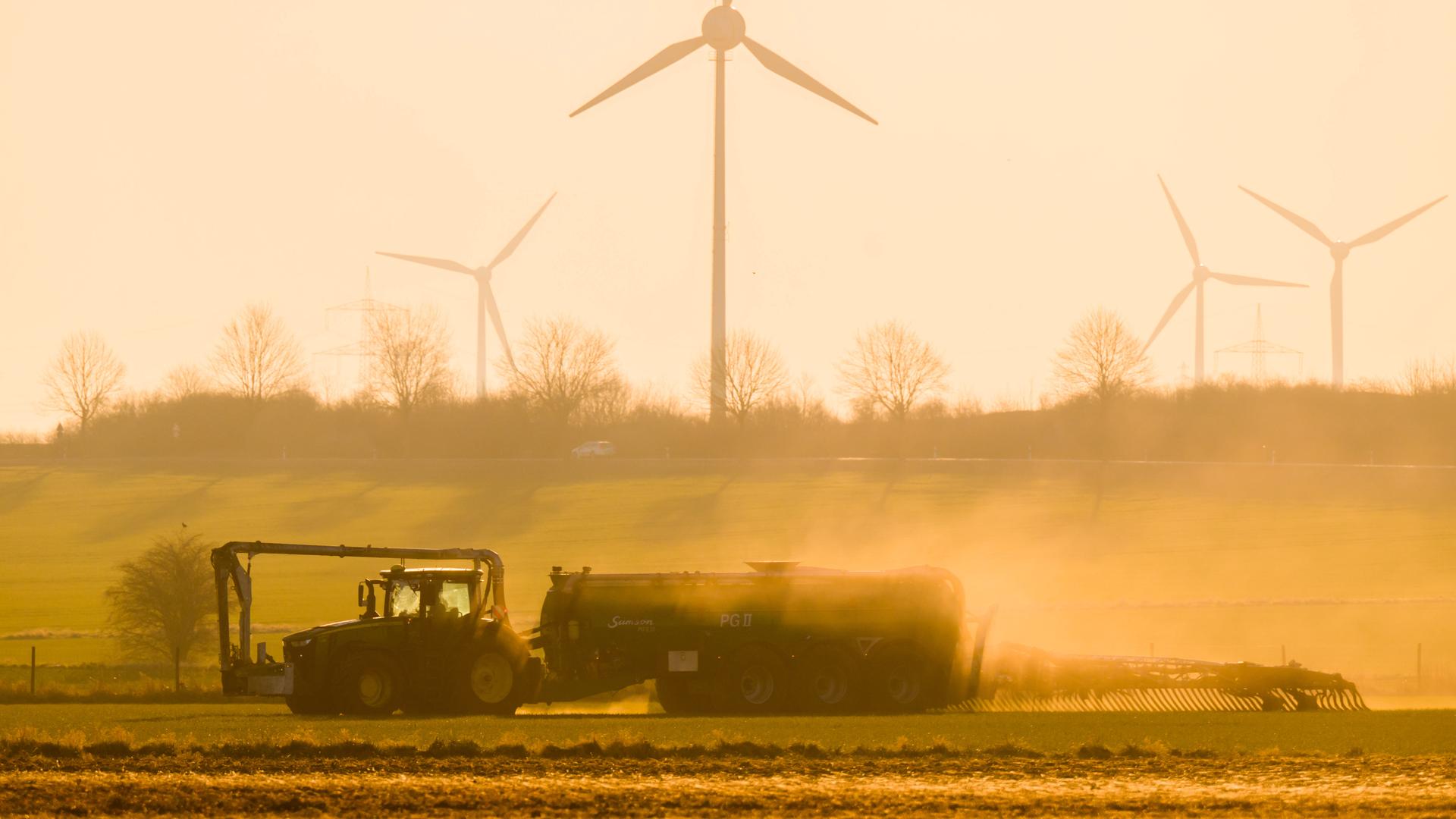 Mit einem Traktor wird bei Sonnenaufgang ein Feld in der Region Hannover mit Gülle gedüngt. Mit einem Traktor wird bei Sonnenaufgang ein Feld in der Region Hannover mit Gülle gedüngt.
