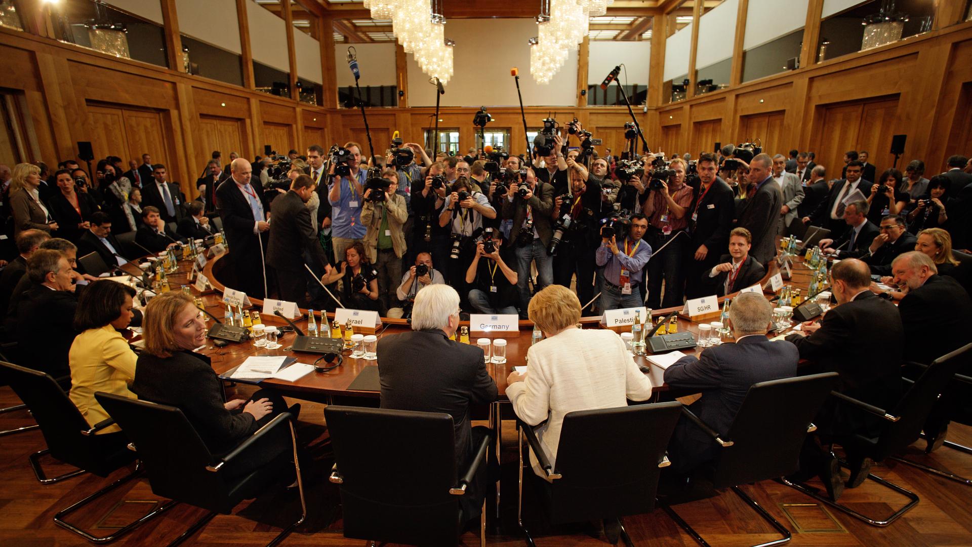 Angela Merkel und Frank-Walter Steinmeier sitzen vor einer großen Gruppen an Pressefotografen im Auswaertigen Amt . 