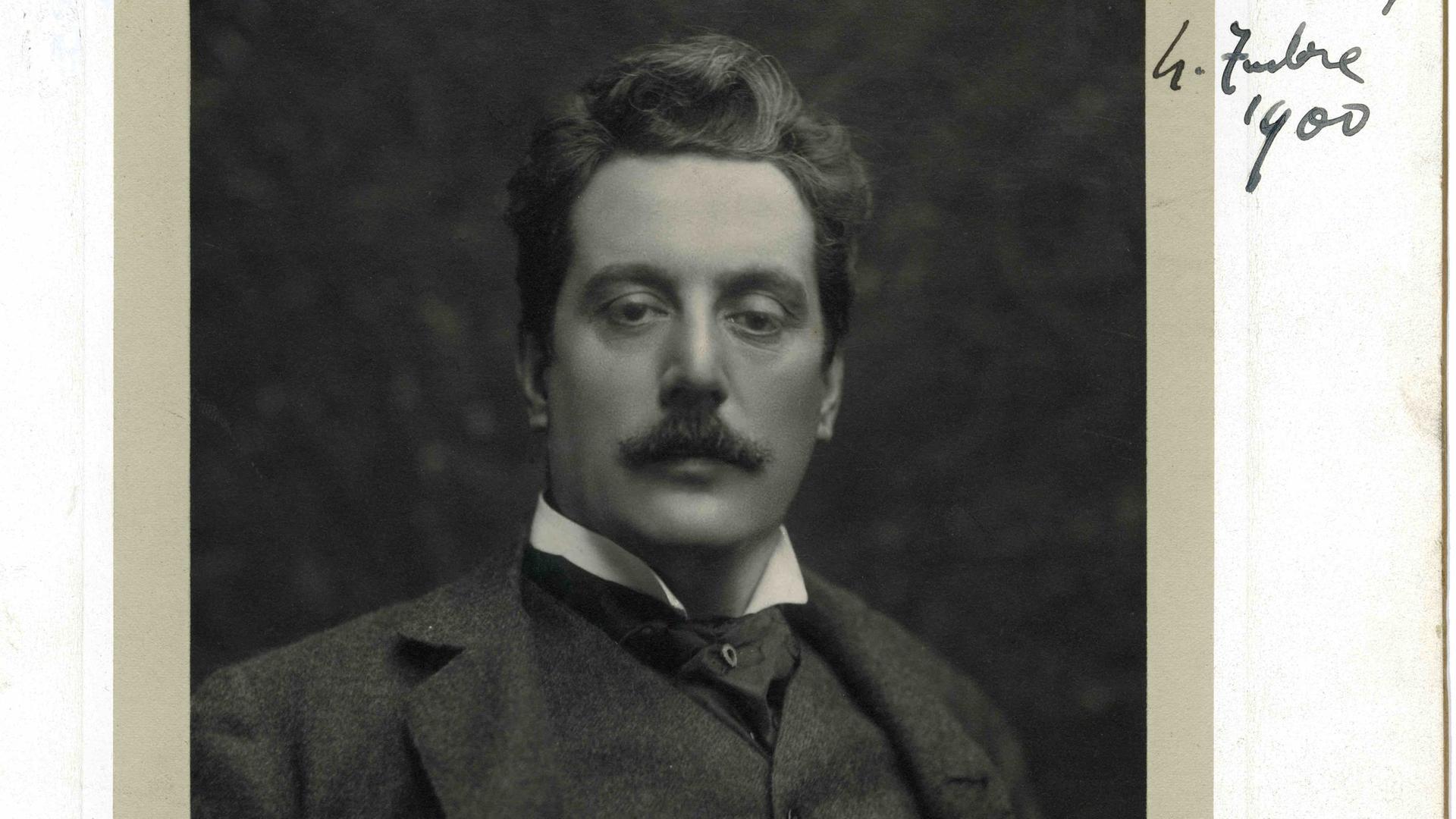 Puccini im mittleren Alter, vollem Haar und stolzem Blick auf einer historischen Fotografie.