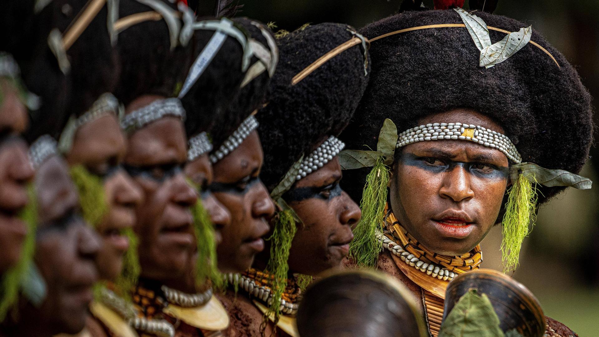 Mehrere Männer in traditioneller Kriegsbemalung stehen beim Sing-Sing-Festival in Mount Hagen nebeneinander.