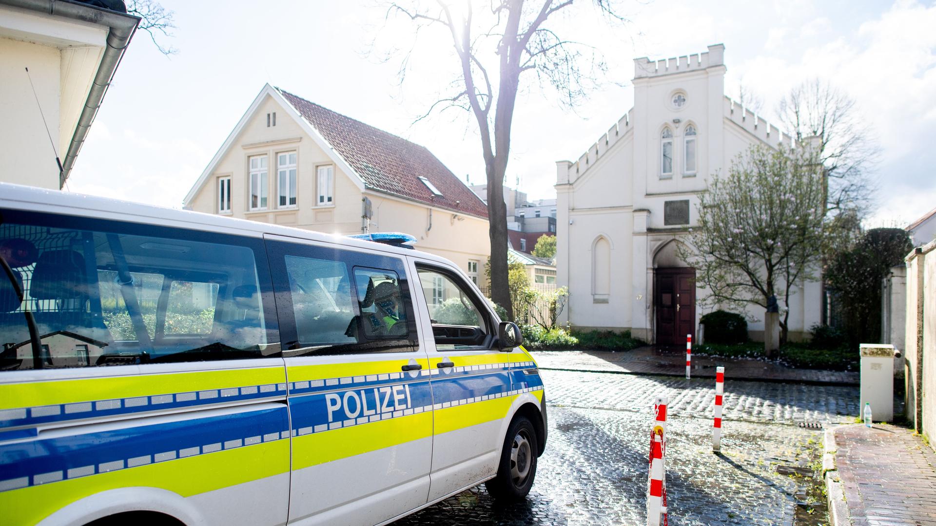 Ein Einsatzfahrzeug der Polizei steht vor der Synagoge im Stadtzentrum. An der Eingangstür sind schwarze Spuren eines Brandsatzes. Ein Einsatzfahrzeug der Polizei steht vor der Synagoge im Stadtzentrum. An der Eingangstür sind schwarze Spuren eines Brandsatzes.