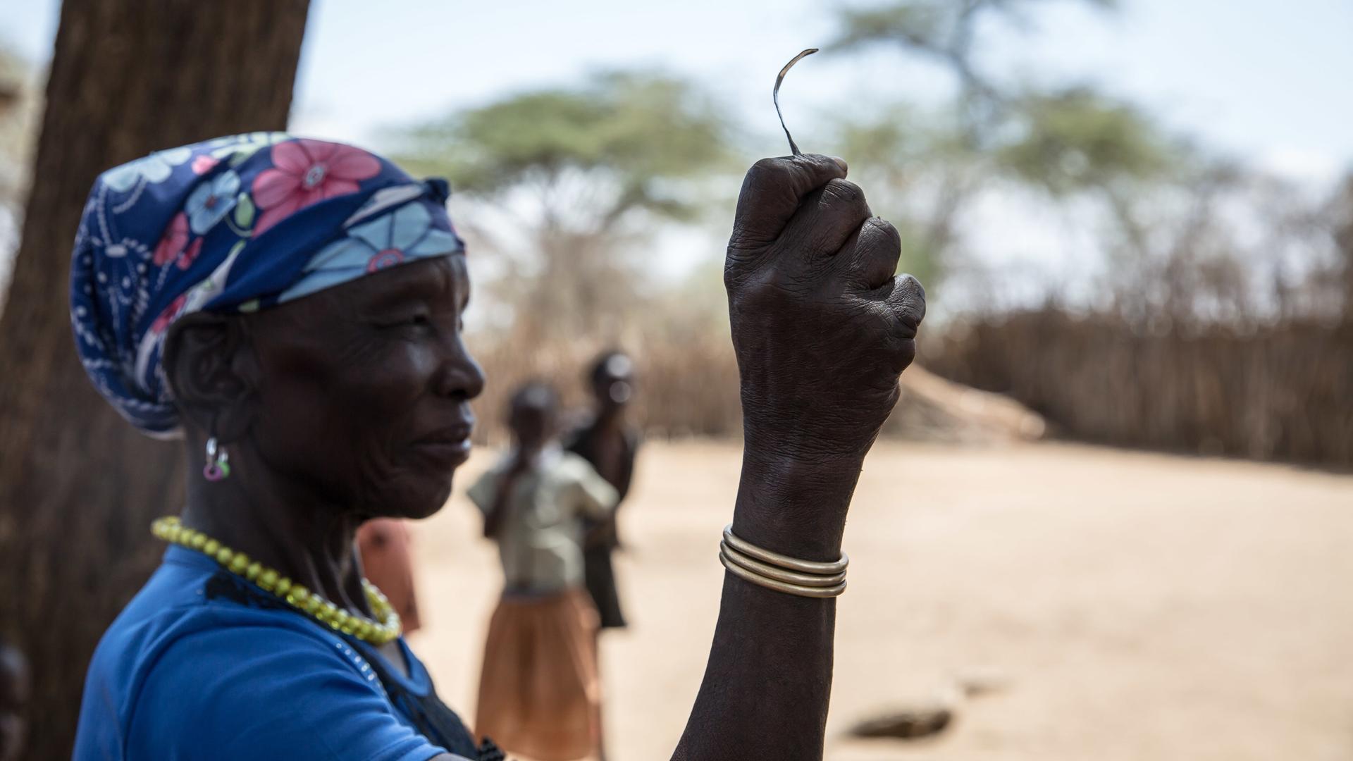 Eine Aufnahme aus dem Jahr 2018 zeigt eine Frau in einem Dorf in Uganda, die nach eigener Aussage die „Vorsitzende der Messerschneider“ in ihrem Stamm gewesen ist, bevor die weibliche Genitalverstümmelung (FGM) 2010 in Uganda verboten wurde. Sie zeigt das Werkzeug, mit dem sie junge Mädchen beschnitten hat. 