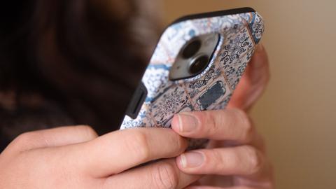 Zwei Hände tippen auf einem Smartphone