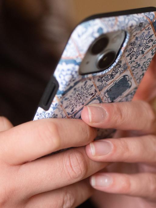 Zwei Hände tippen auf einem Smartphone