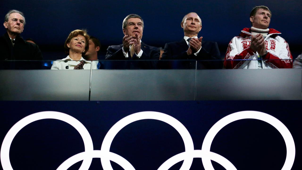 Russlands Präsident Vladimir Putin und IOC-Präsident Thomas Bach stehen gemeinsam bei der Abschlussfeier in Sotchi 2014, unter sich die Olympische Ringe.