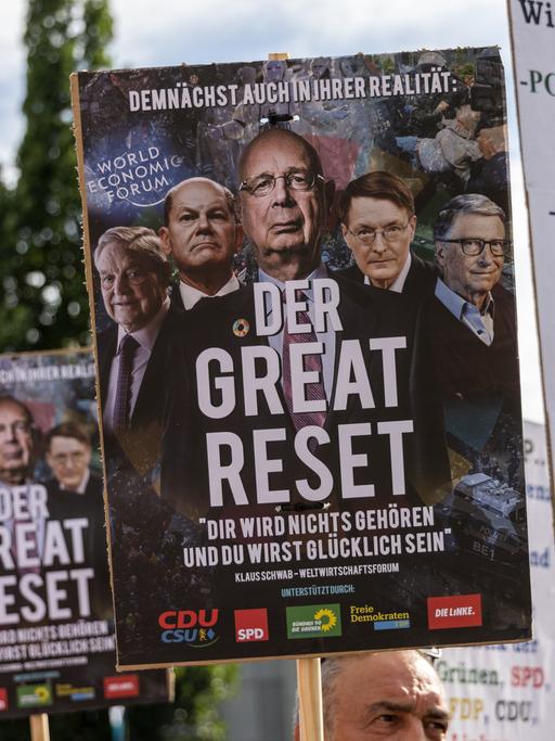 Ein Demonstrant hält ein Schild mit der Aufschrift "The Great Reset!", während er und andere Demonstranten sich versammeln, um ein Ende des geplanten deutschen Embargos gegen die Einfuhr von russischem Öl zu fordern.
