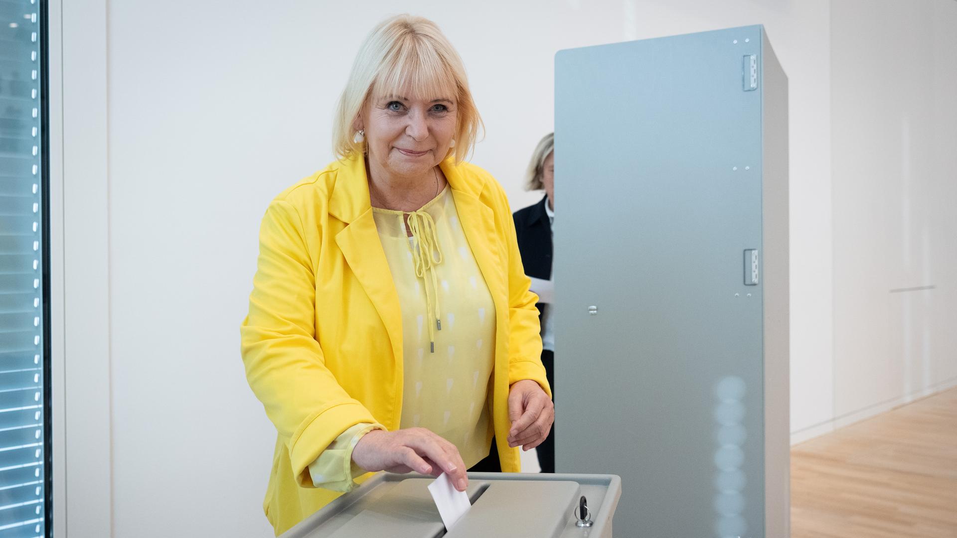 Ulrike Liedtke - in gelb gekleidet - steckt während der konstituierenden Sitzung ihren Wahlzettel in die Urne. Sie lächelt. Ulrike Liedtke - in gelb gekleidet - steckt während der konstituierenden Sitzung ihren Wahlzettel in die Urne. Sie lächelt.