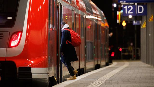 Ein Reisender steigt am Frankfurter Hauptbahnhof in einen Regionalzug ein