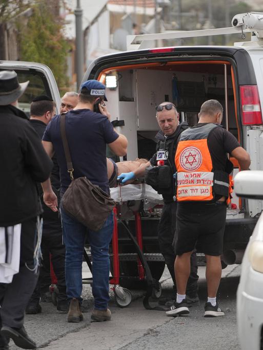 Rettungskräfte schieben einen auf einer Trage liegenden Mann in einen Rettungswagen in Jerusalem.