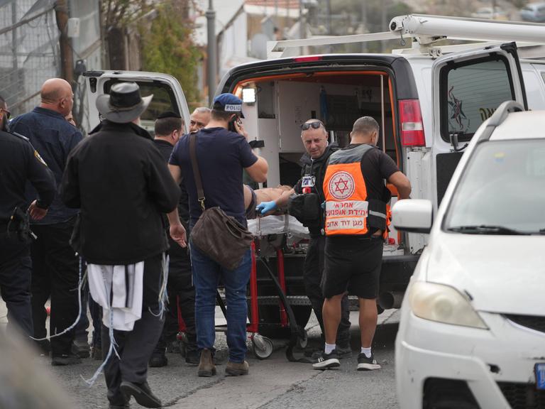 Rettungskräfte schieben einen auf einer Trage liegenden Mann in einen Rettungswagen in Jerusalem.