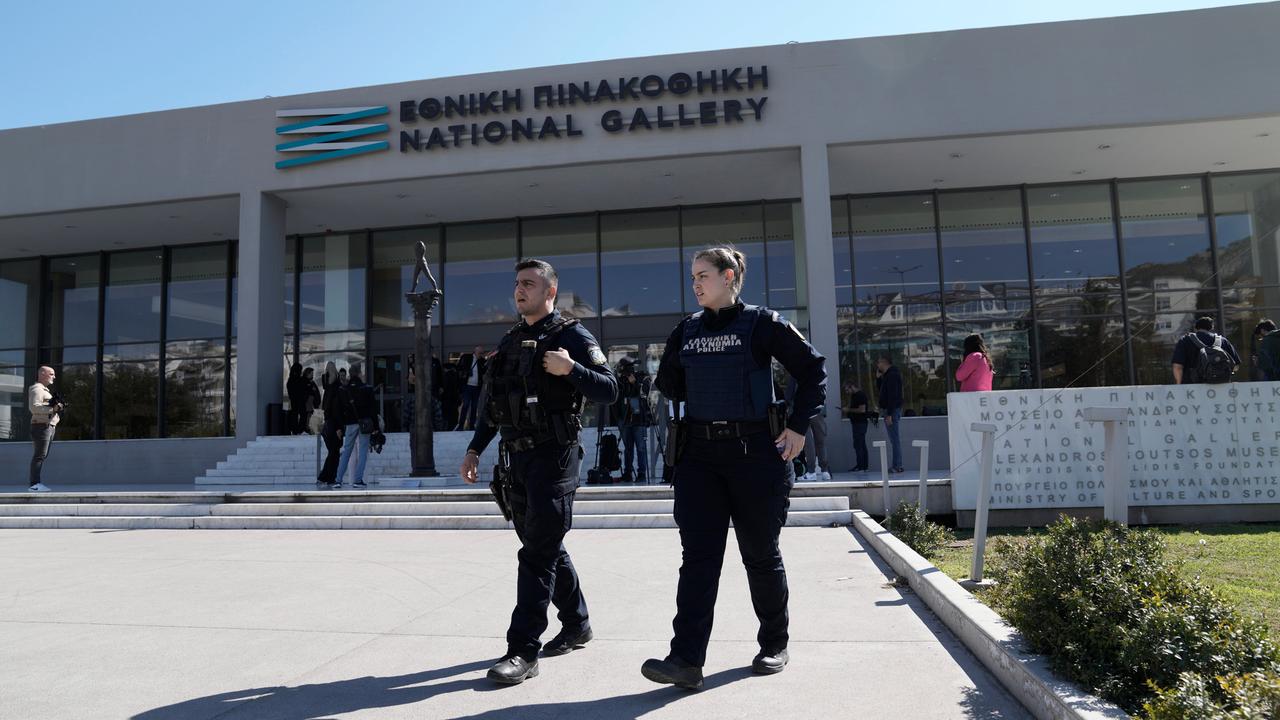 Griechische Polizeibeamte gehen vor der Nationalgalerie.