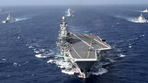 Luftaufnahme vom südchinesischen Meer: in der Mitte der Flugzeugträger „Liaoning“, im Hintergrund weitere Boote.