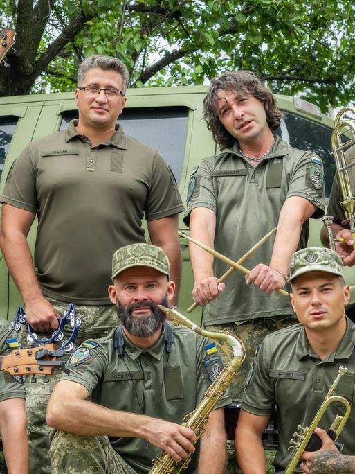 Acht Musiker des "Cultural Forces" Orchesters mit ihren Instrumenten in Uniform.