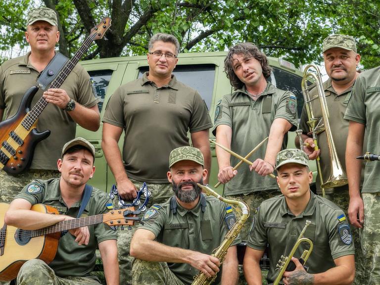 Acht Musiker des "Cultural Forces" Orchesters mit ihren Instrumenten in Uniform.