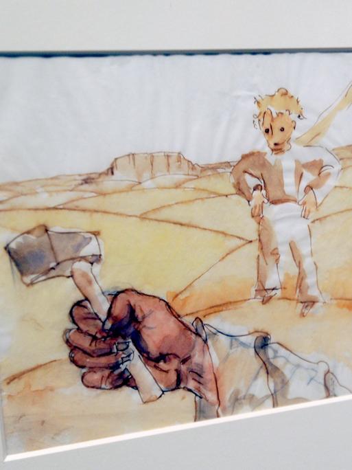 Der kleine Prinz ist in einer farbigen Zeichnung zu sehen; im Vordergrund ist ein Arm zu sehen, der einen Hammer hält.