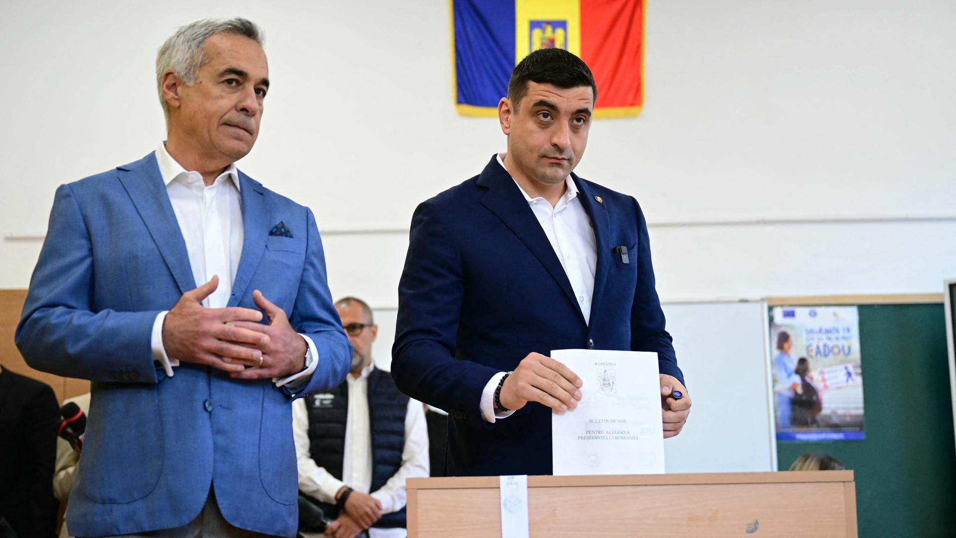 Simion, der Kanidat der rechtsnationalen AUR-Partei wirft seinen Stimmzettel in eine Wahlurne. Neben ihm steht der disqualifizierte Kandidat Georgescu. Simion, der Kanidat der rechtsnationalen AUR-Partei wirft seinen Stimmzettel in eine Wahlurne. Neben ihm steht der disqualifizierte Kandidat Georgescu.