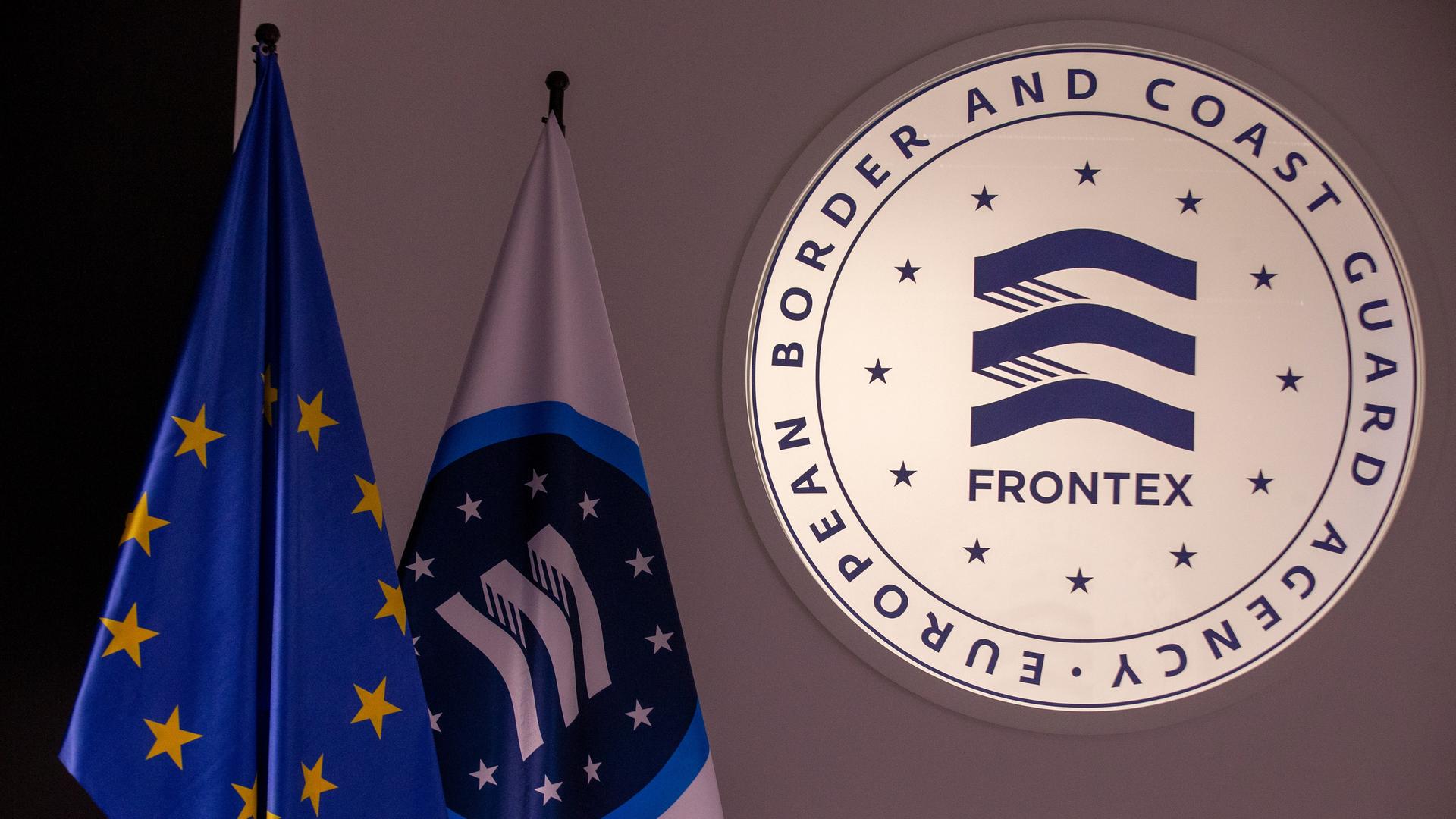 Das Frontex-Logo neben einer Frontex- und einer EU-Flagge.