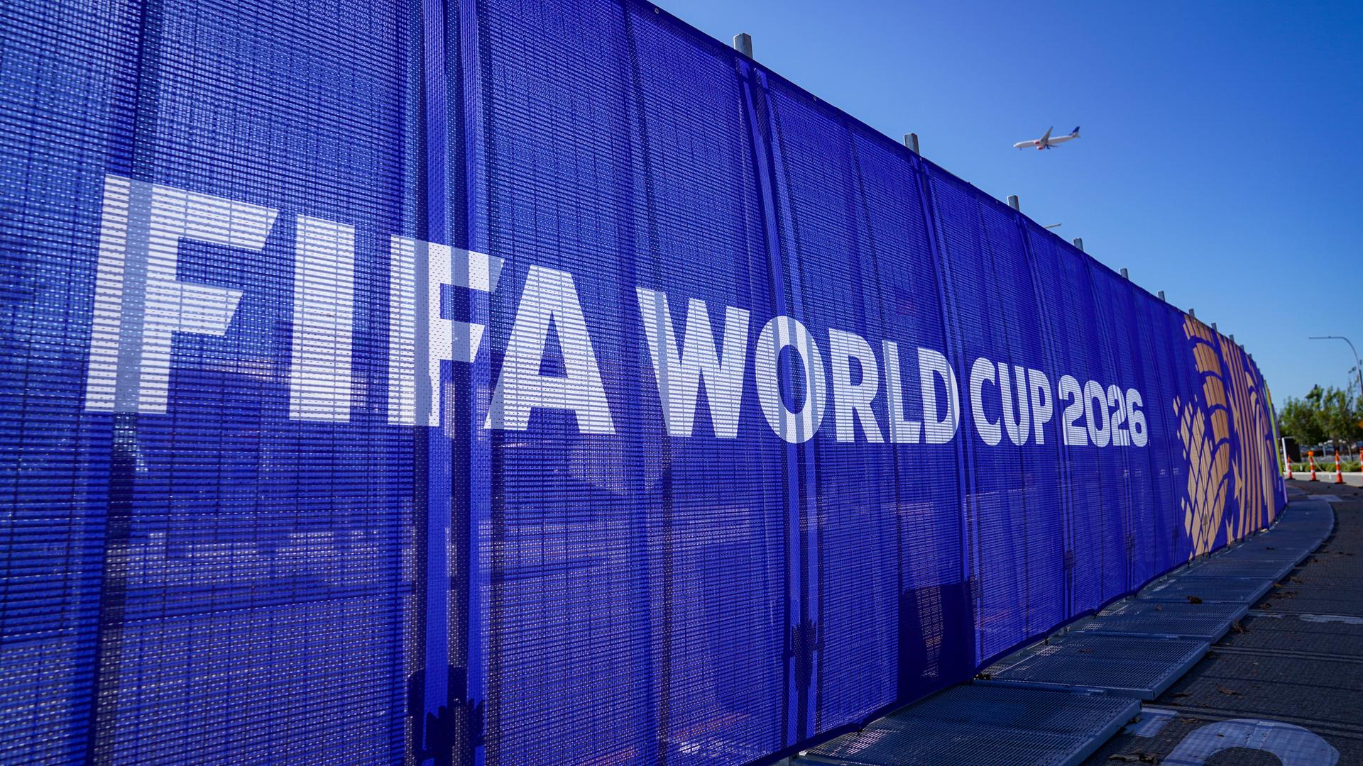 Auf einem blauen Banner steht in großen Buchstaben "Fifa World Cup 2026"
