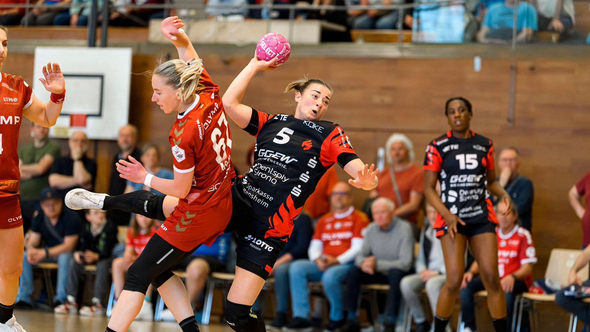 Die Spielerinnen kämpfen um den Ball. Veronika Mala wirft. Im Hintergrund sieht man die Zuschauer.